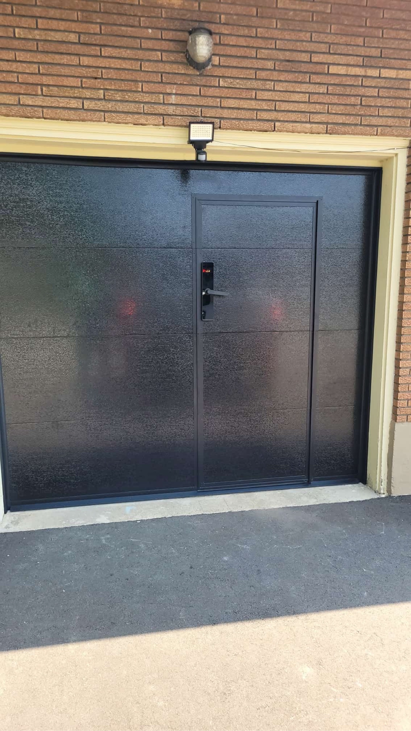 Black walk-through garage door with smart lock