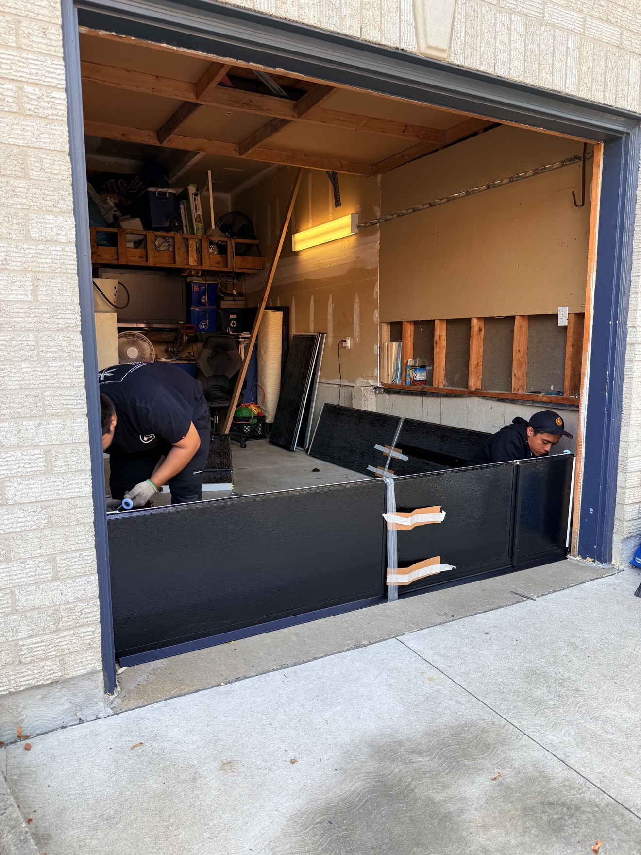 Crew fitting the first garage door panels on site